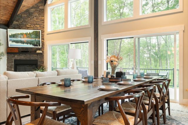The long table from the kitchen side, set under the loft with the fire lit.