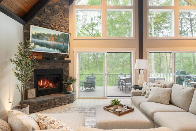 The great room with the stacked-stone fireplace lit