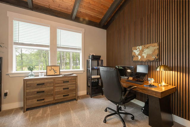 The loft above the great room, set up as a quiet workspace — slatted feature wal
