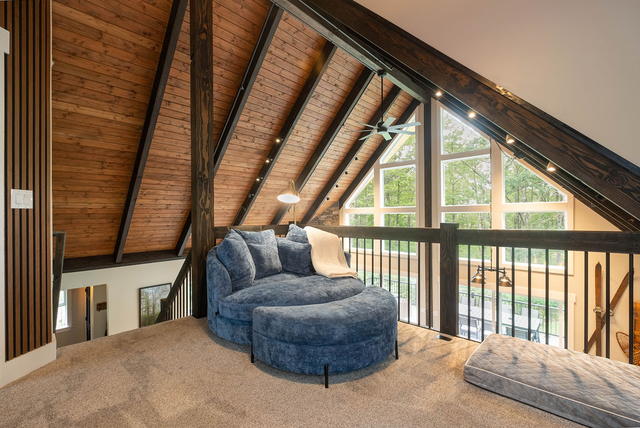 The round chaise in the loft nook, tucked under the slope with the treetops out 