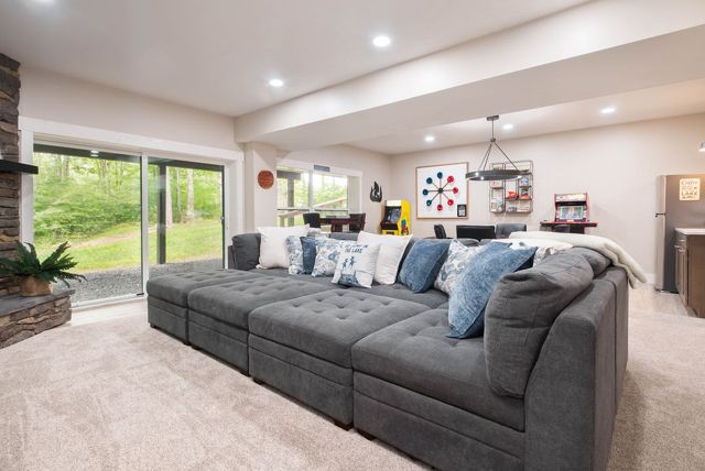 The lower level opens wide — a pit sectional the length of the room, the game ar