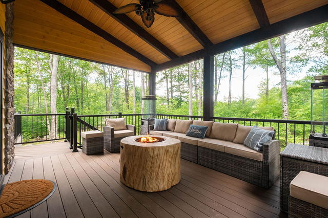 The covered deck from the other end — wicker seating either side of the fire ta