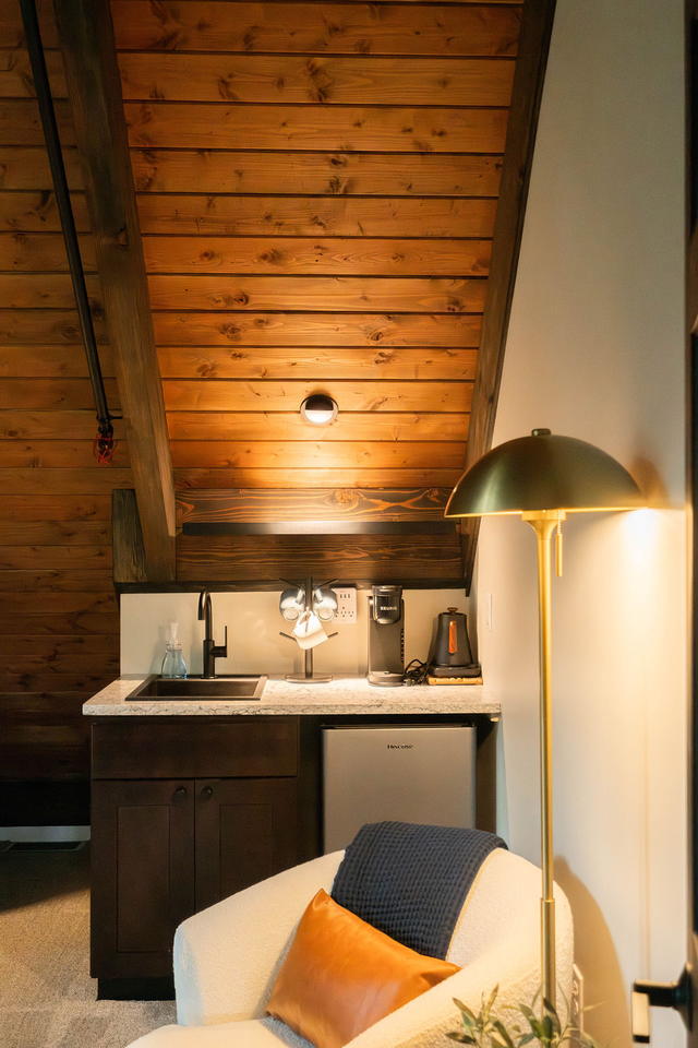 The coffee bar and reading chair in the corner of the suite — sink, mini-fridge,